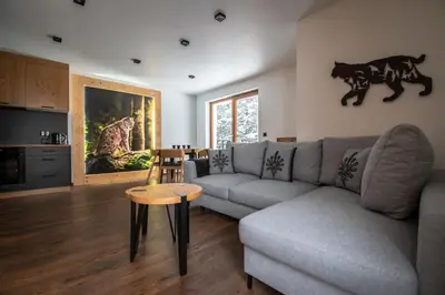 a living room with a couch and a table at Cyrhel Apartments in Zawoja