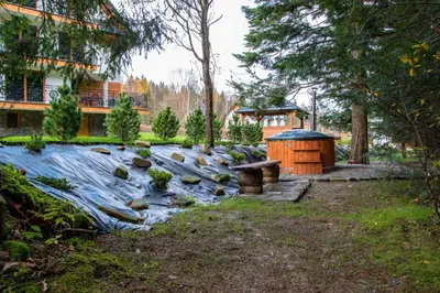a river with rocks in a yard with a building at Cyrhel Apartments in Zawoja