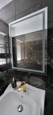 a bathroom sink with a mirror and a window above it at La Casa De Roland in Wieliczka
