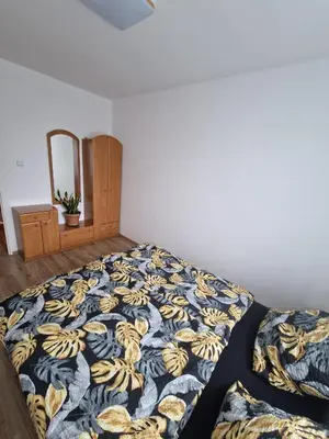 a bed with a blue and yellow blanket on it at La Casa De Roland in Wieliczka