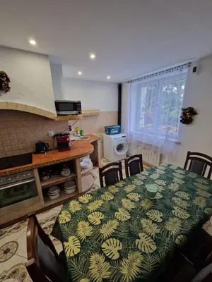 a dining room with a table and chairs and a kitchen at La Casa De Roland in Wieliczka