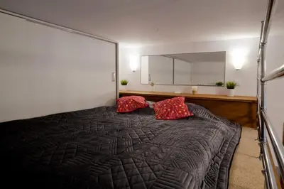 a bedroom with a large bed with two red pillows at Magic Apartment in Kraków