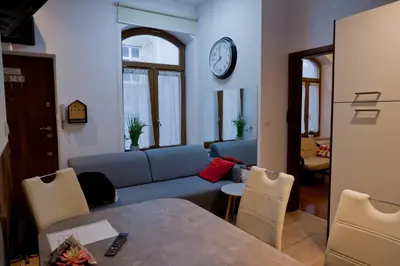 a living room with a couch and a clock on the wall at Magic Apartment in Kraków
