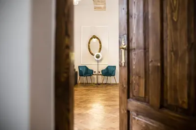a hallway with two blue chairs and a mirror at CracWoW K8 No.1 Apartment in Kraków