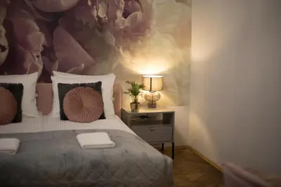 a bedroom with a bed and a lamp on a table at CracWoW K8 No.1 Apartment in Kraków