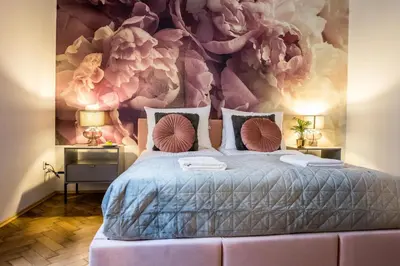 a bedroom with a bed with a floral wall at CracWoW K8 No.1 Apartment in Kraków
