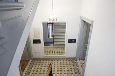 a hallway with a stairway with a mirror and a room at CracWoW K8 No.1 Apartment in Kraków
