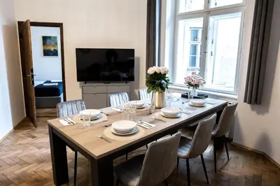 a dining room table with chairs and a large window at CracWoW K8 No.1 Apartment in Kraków