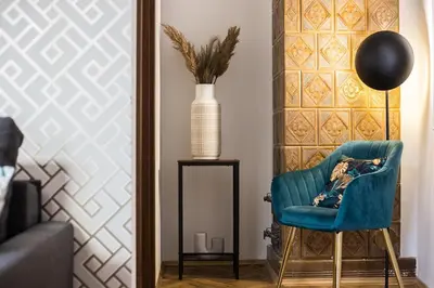 a living room with a blue chair and a vase at CracWoW K8 No.2 Apartment in Kraków