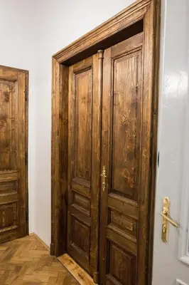 a wooden door in a room with a wall at CracWoW K8 No.2 Apartment in Kraków