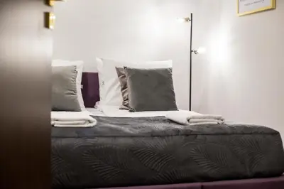 a bedroom with a bed with pillows and a mirror at CracWoW K8 No.2 Apartment in Kraków