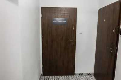 a wooden door with a sign on it in a room at CracWoW K8 No.2 Apartment in Kraków