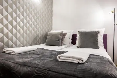 a bed with white blankets and pillows on it at CracWoW K8 No.2 Apartment in Kraków