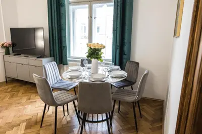 a dining room with a table with chairs and a television at CracWoW K8 No.8 Apartment in Kraków