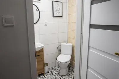 a small bathroom with a toilet and a sink at CracWoW K8 No.8 Apartment in Kraków