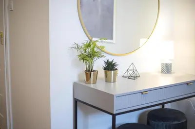a dressing table with plants and a mirror at CracWoW K8 No.9 Apartment in Kraków