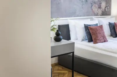 a bedroom with a bed with pillows and a table at CracWoW K8 No.9 Apartment in Kraków