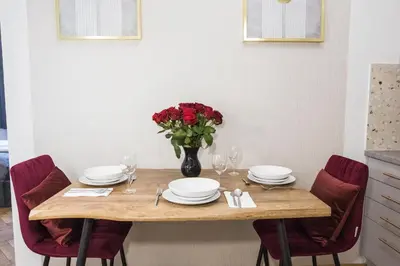 a dining room table with plates and a vase of flowers at CracWoW K8 No.9 Apartment in Kraków