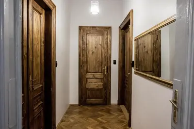 a hallway with two wooden doors and a staircase at CracWoW K8 No.9 Apartment in Kraków