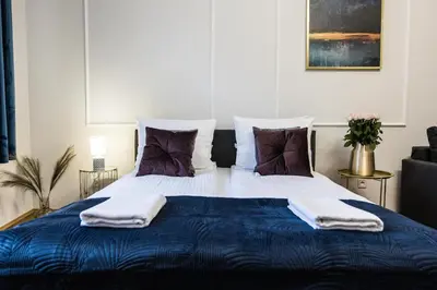 a bedroom with a large bed with towels on it at CracWoW K8 No.10 Apartment in Kraków