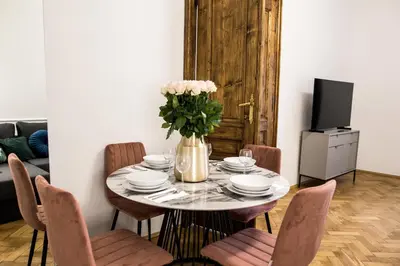 a dining room table with chairs and a vase of flowers at CracWoW K8 No.10 Apartment in Kraków