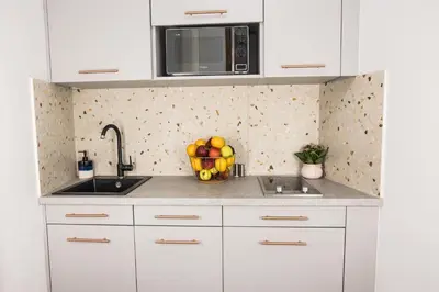 a kitchen with white cabinets and a bowl of fruit at CracWoW K8 No.10 Apartment in Kraków