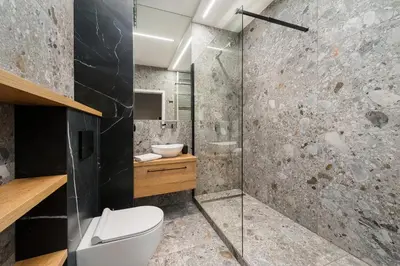 a bathroom with a toilet and a glass shower at Krakowiak Apartment 65 in Kraków