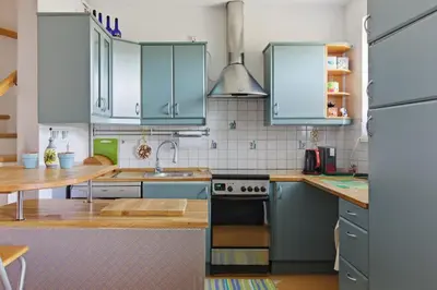 a kitchen with blue cabinets and a sink at Bronowice - large and modern apartment with free parking spot in Kraków