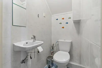 a white bathroom with a toilet and a sink at Bronowice - large and modern apartment with free parking spot in Kraków
