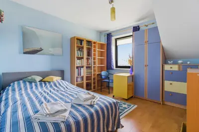 a bedroom with a bed and a book shelf at Bronowice - large and modern apartment with free parking spot in Kraków