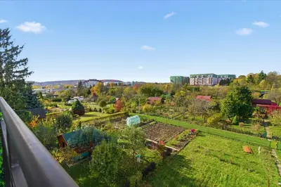 a view of a garden from a balcony at Bronowice - large and modern apartment with free parking spot in Kraków