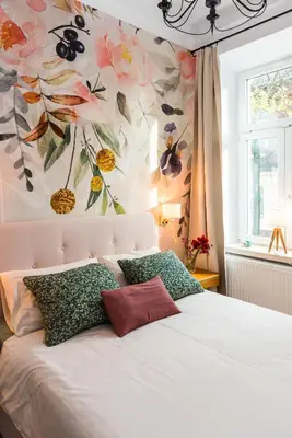 a bedroom with a white bed with a flower wallpaper at Flora Design Old Town- Free Parking in Kraków