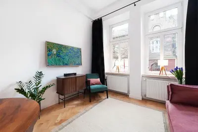a living room with a table and a chair at Flora Design Old Town- Free Parking in Kraków