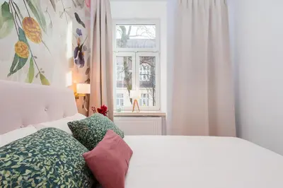 a bedroom with a white bed and a window at Flora Design Old Town- Free Parking in Kraków