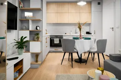 a kitchen and living room with a table and chairs at Kraków Central Comfort Apartments by Rentujemy in Kraków