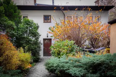 a white house with a brown door and some bushes at Kraków Central Comfort Apartments by Rentujemy in Kraków