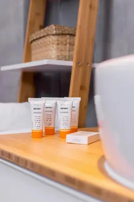 a group of three bottles of orange liquid on a counter at Cracow Apartment Bronowicka with Parking by Noclegi Renters in Kraków