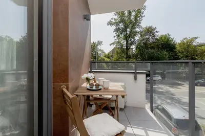 a small balcony with a table and chairs on a patio at Cracow Apartment Bronowicka with Parking by Noclegi Renters in Kraków