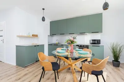 a kitchen and dining room with a table and chairs at Cracow Apartment Bronowicka with Parking by Noclegi Renters in Kraków
