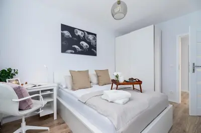 a white living room with a couch and a desk at Cracow Apartment Bronowicka with Parking by Noclegi Renters in Kraków