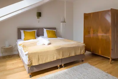 a bedroom with a large bed with yellow pillows at Charming apartment in perfect location in Kraków