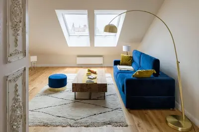 a living room with a blue couch and a table at Charming apartment in perfect location in Kraków