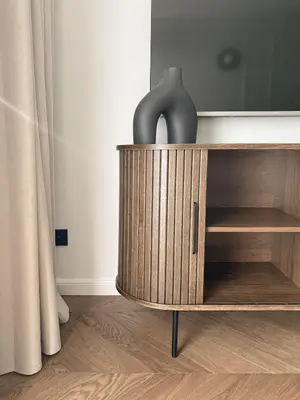 a wooden cabinet with a vase on top of it at Apartament BonHaus Grzegórzecka in Kraków