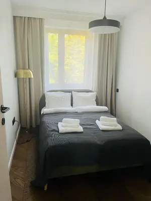 a bedroom with two towels on a bed with a window at Apartament BonHaus Grzegórzecka in Kraków