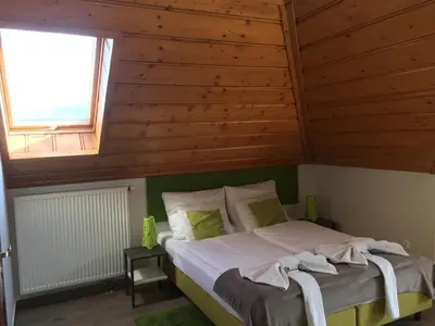 a bed in a room with a wooden ceiling at Apartamenty Lawenda in Rabka