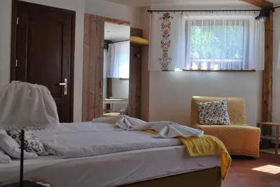 a bedroom with two beds and a chair and a window at Apartamenty Lawenda in Rabka