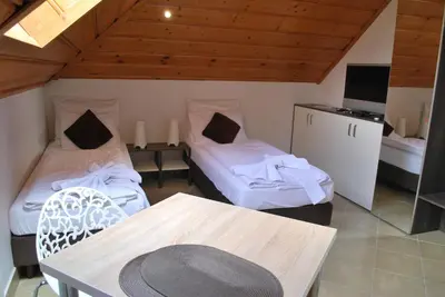 a room with two beds and a table and a tv at Apartamenty Lawenda in Rabka