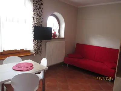 a living room with a red couch and a table at Apartamenty Lawenda in Rabka