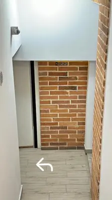a room with a brick wall and a white arrow at Apartment Family Dreams Old Town in Kraków