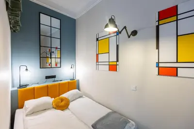 a bedroom with a bed and some stained glass windows at Vintage Studencka 1 Apartment in Kraków